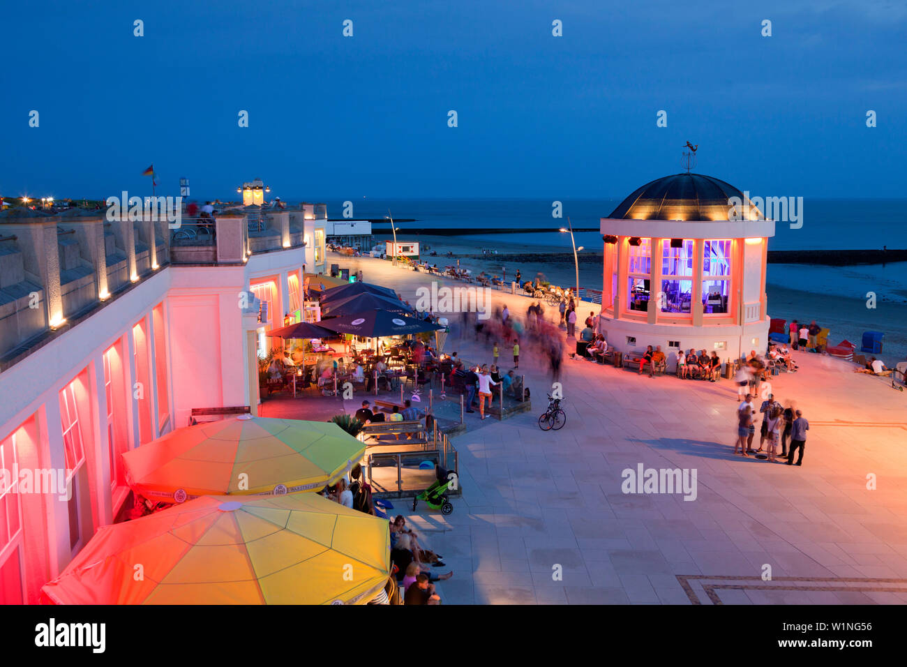 People sitting in a cafe on the beach promenade, Pavilion in the background, Borkum, Ostfriesland, Lower Saxony, Germany Stock Photo