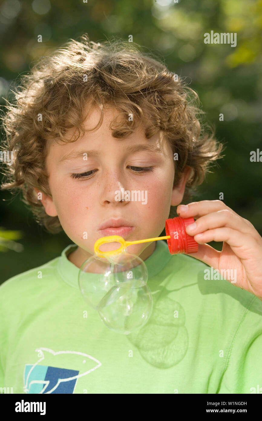 Boy blowing soap bubbles, children's birthday party Stock Photo Alamy