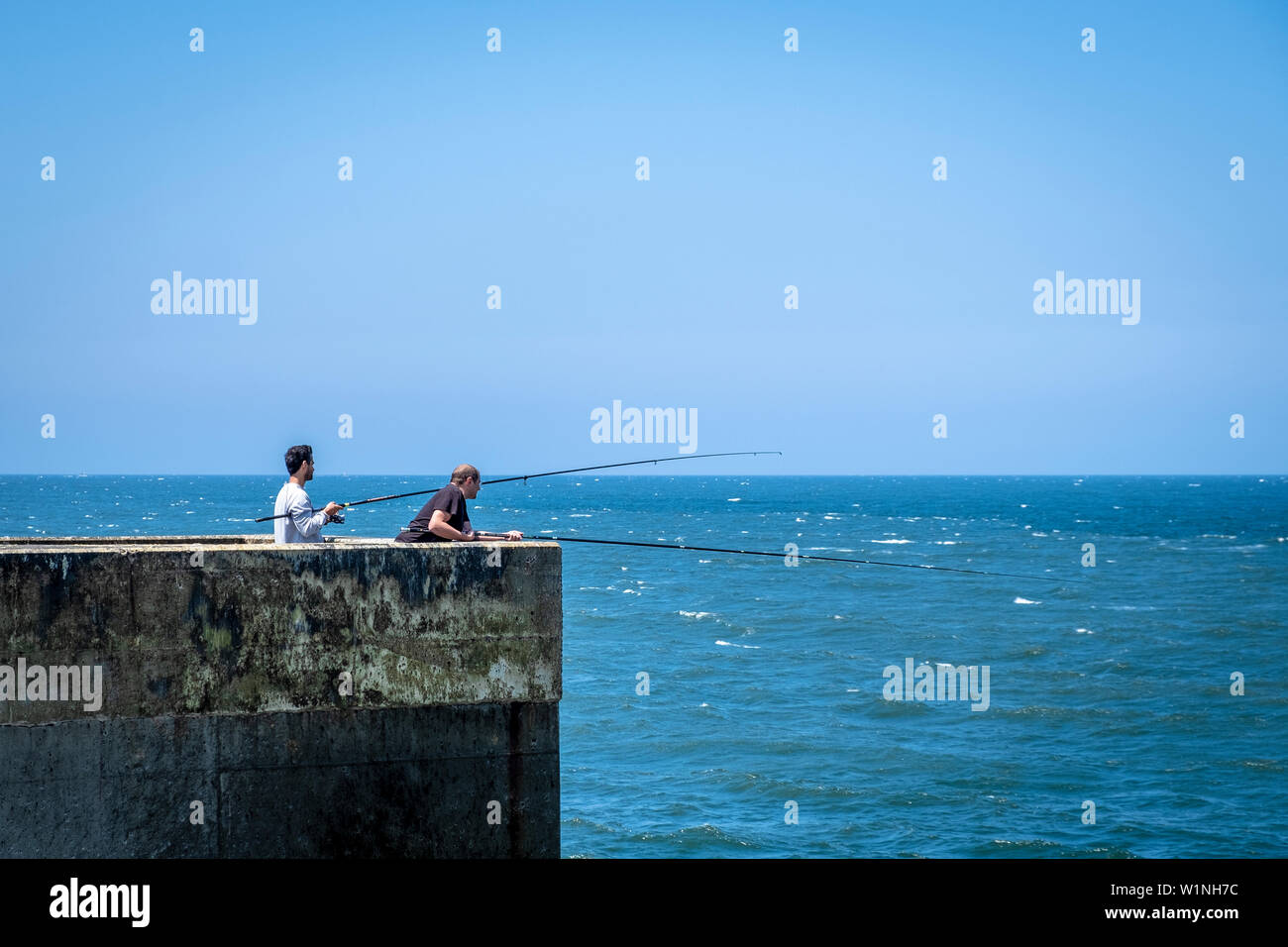 Guys fishing at Farolins da Barra do Douro. Porto. Portugal Stock Photo