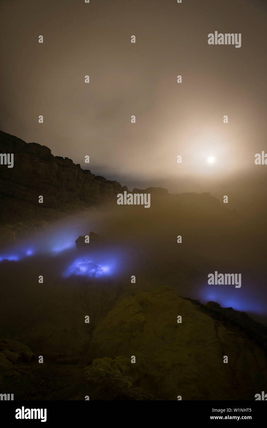 Burning sulfur of the volcano Ijen with blue flames during the night. Full moon and stars. - Indonesia, East Java, Ijen volcano Stock Photo