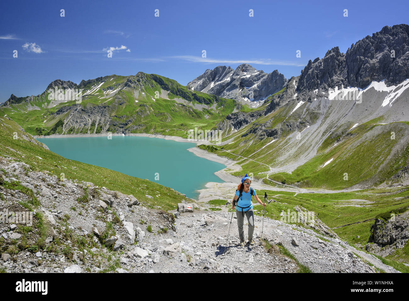 Woman hiking with lake Luenersee in background, lake Luenersee, Raetikon trail, Raetikon, Vorarlberg, Austria Stock Photo