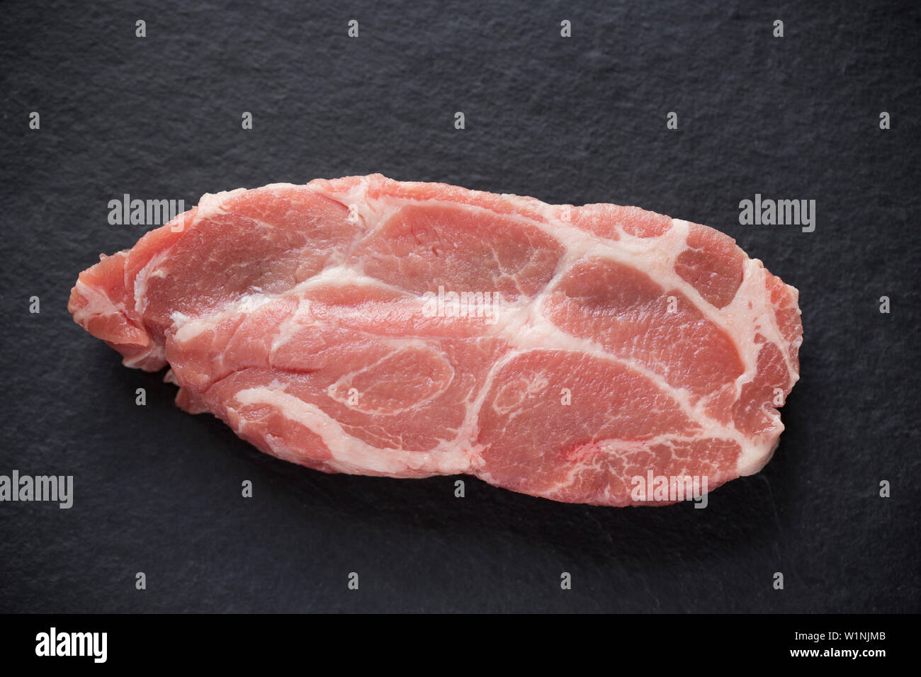 One raw, uncooked British pork shoulder steak bought from a supermarket in the UK. Dorset England UK GB Stock Photo
