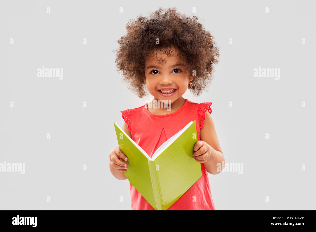 happy little african american girl reading book Stock Photo - Alamy
