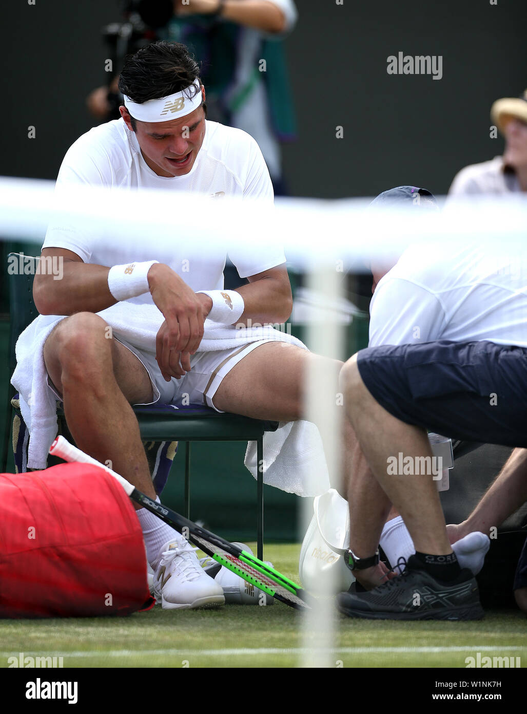 Milos Raonic receives medical care during day three of the Wimbledon Championships at the All England Lawn Tennis and Croquet Club, London. Stock Photo