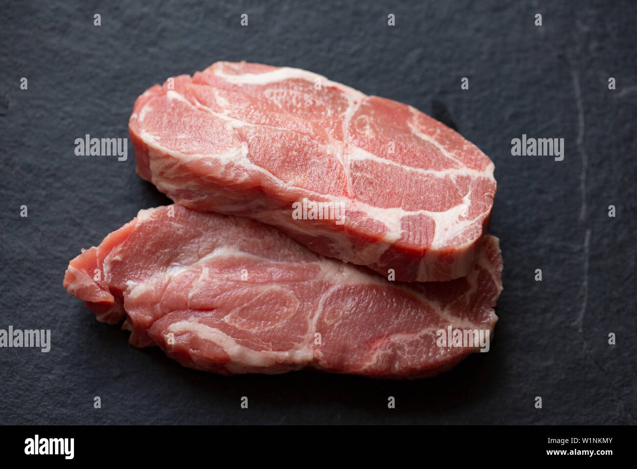 Two raw, uncooked British pork shoulder steaks bought from a supermarket in the UK. Dorset England UK GB Stock Photo