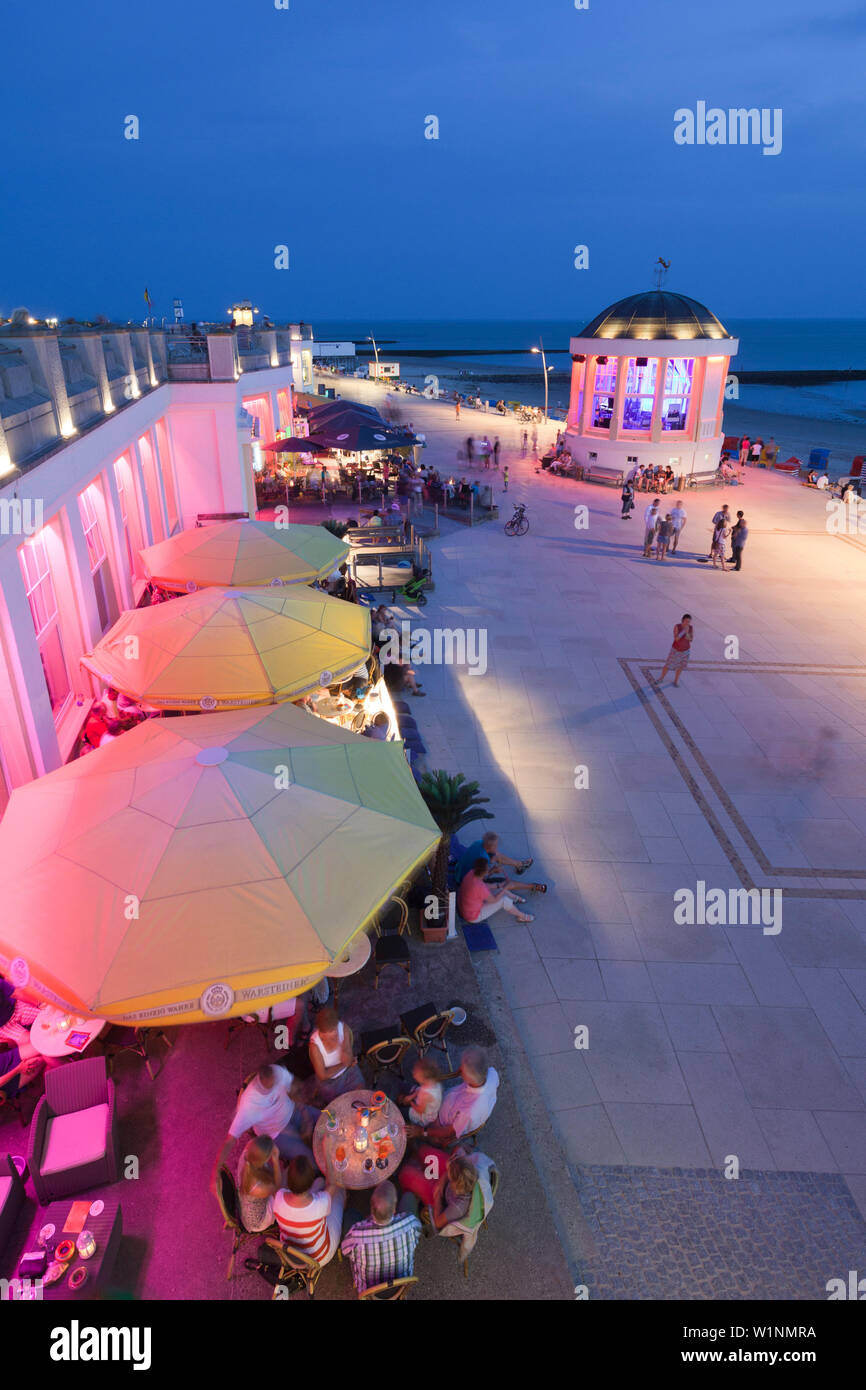 People sitting in a cafe on the beach promenade, Pavilion in the background, Borkum, Ostfriesland, Lower Saxony, Germany Stock Photo