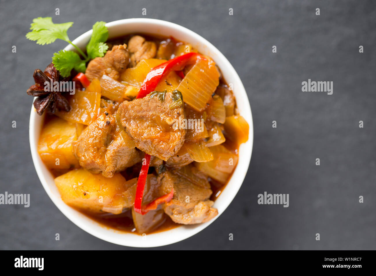 A stew made from cubed British pork shoulder steaks and pineapple chunks bought from a supermarket. The dish includes, chillis, star anise, onions, fi Stock Photo