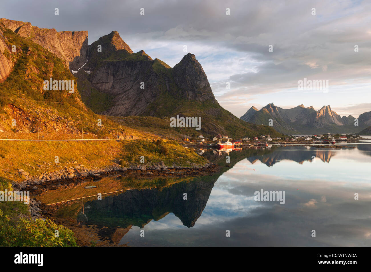 Sea and rocks of the Lofoten island of Moskenesoy with the fishing village of Reine in the morning sun, Lofoten, Norway, Scandinavia Stock Photo