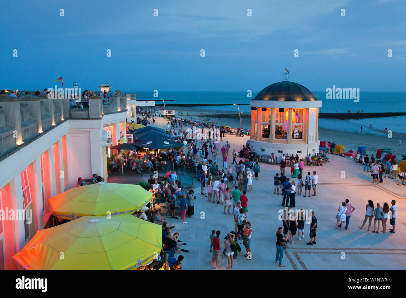 People sitting in a cafe on the beach promenade, Pavilion in the background, Borkum, Ostfriesland, Lower Saxony, Germany Stock Photo