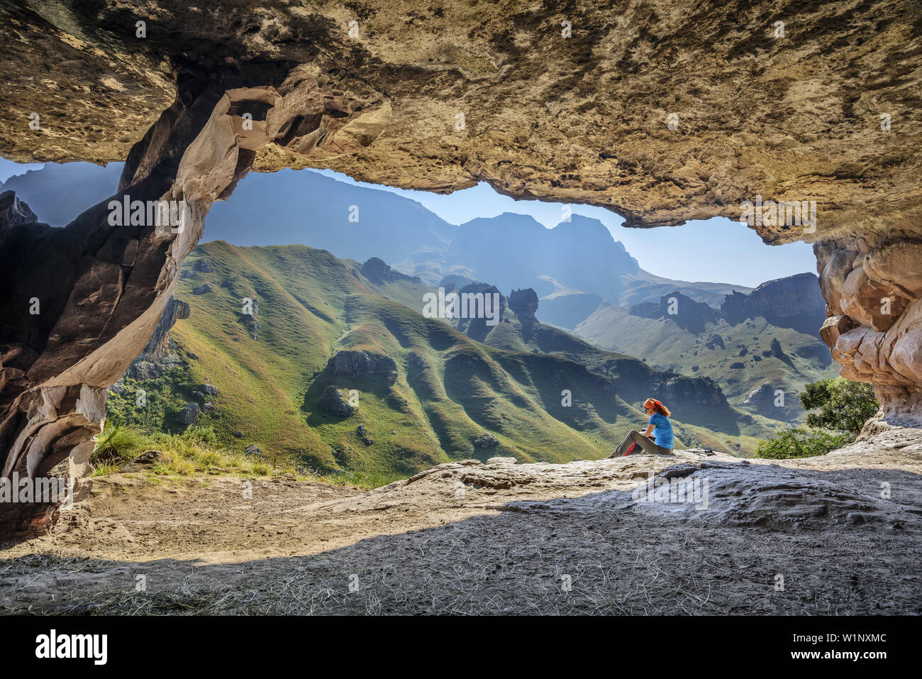 Woman hiking sitting in front of big cave, Pillar Cave, Garden Castle