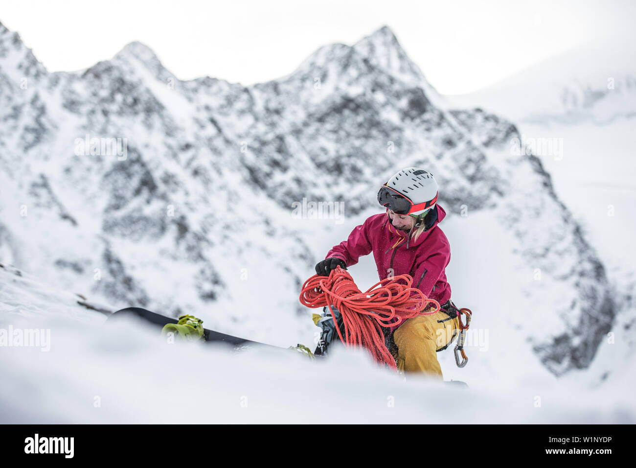 Young female snowboarder preparing her stuff in the mountains, Pitztal, Tyrol, Austria Stock Photo