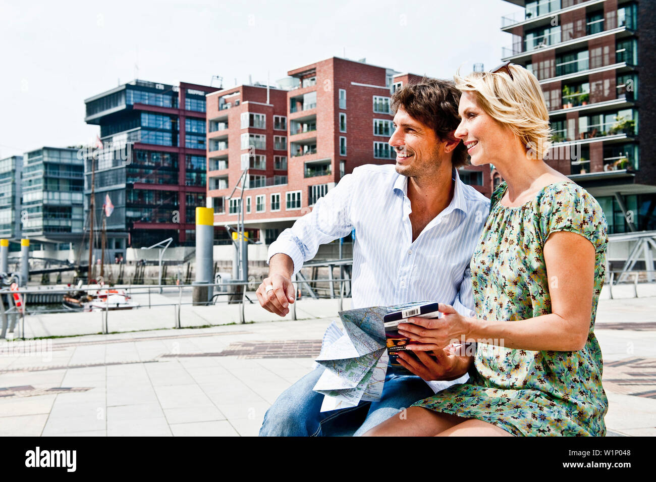 Couple holding a city map at Magellan-Terraces, HafenCity, Hamburg, Germany Stock Photo
