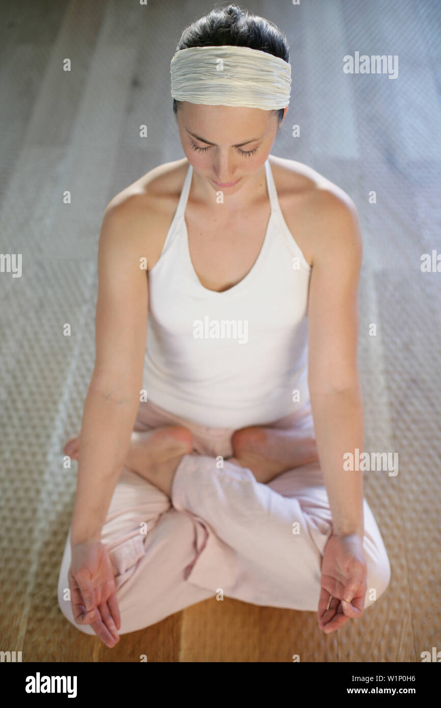 Young woman practising yoga, lotus position Stock Photo