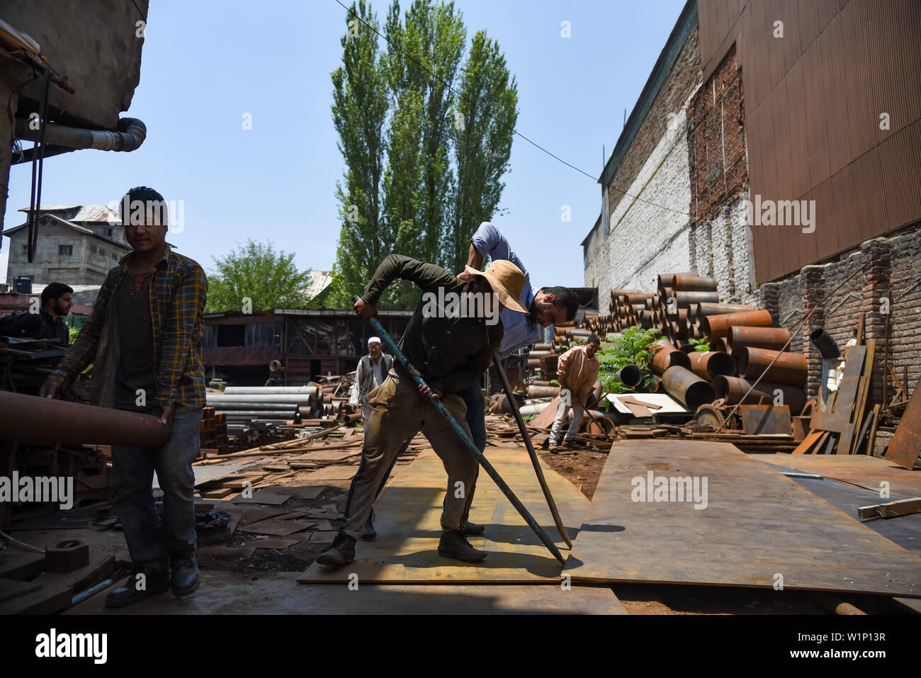 Labourers work inside a scrap shop in Srinagar.Recycling scrap metals ...
