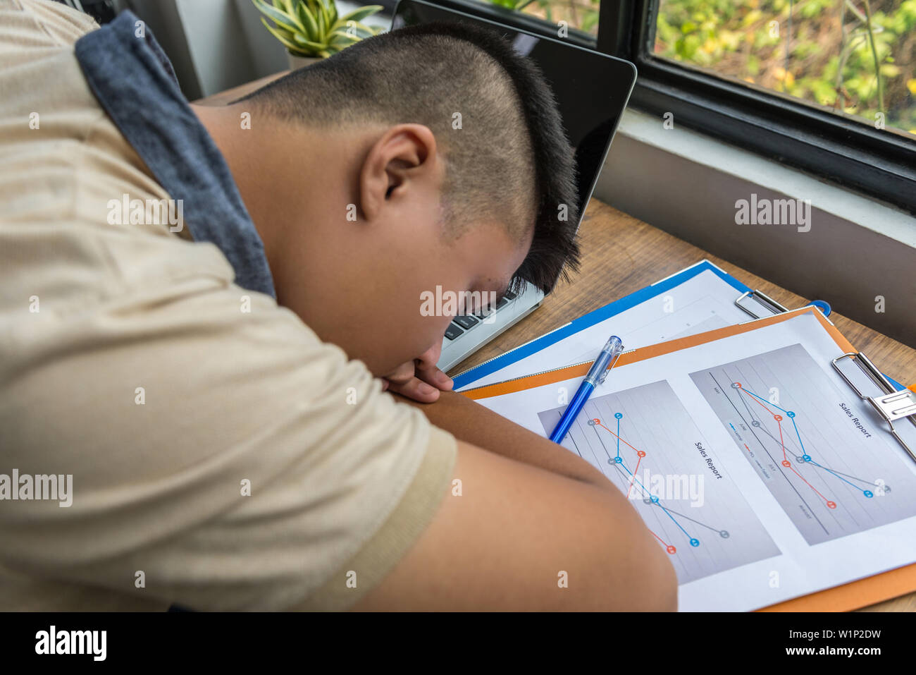 Overworked Asian Man Fall Asleep On Documents On Desk Stock Photo