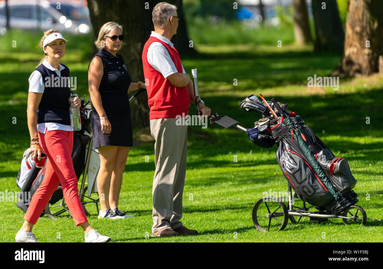 Braunschweig, Germany, May 18., 2019: Older golfers stand with their trolleys on the lawn of the golf course Stock Photo