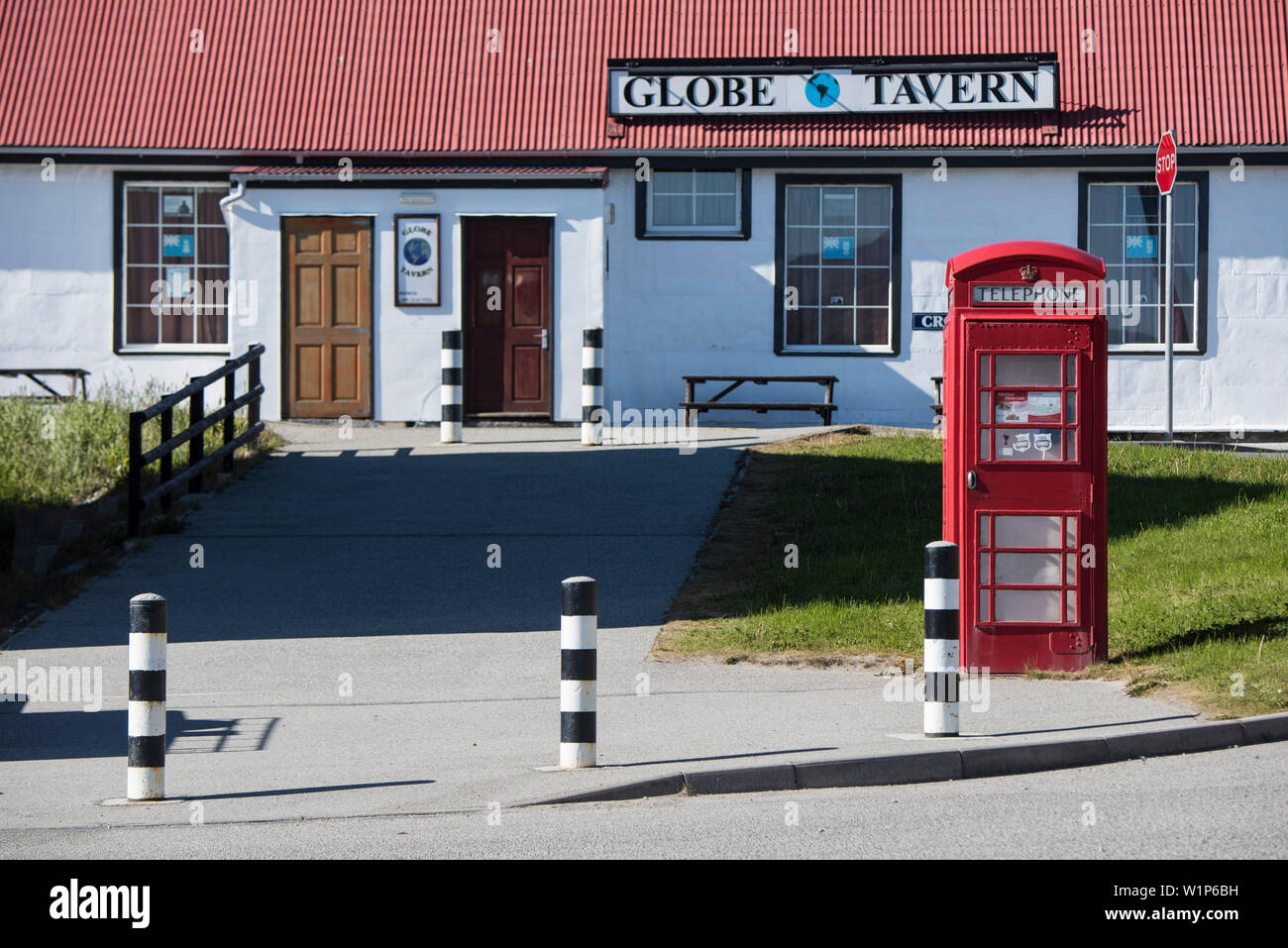 A typical red telephone booth stands in front of the Globe Tavern, one of the capital city's tourist attractions, Stanley, East Falkland, Falkland Isl Stock Photo