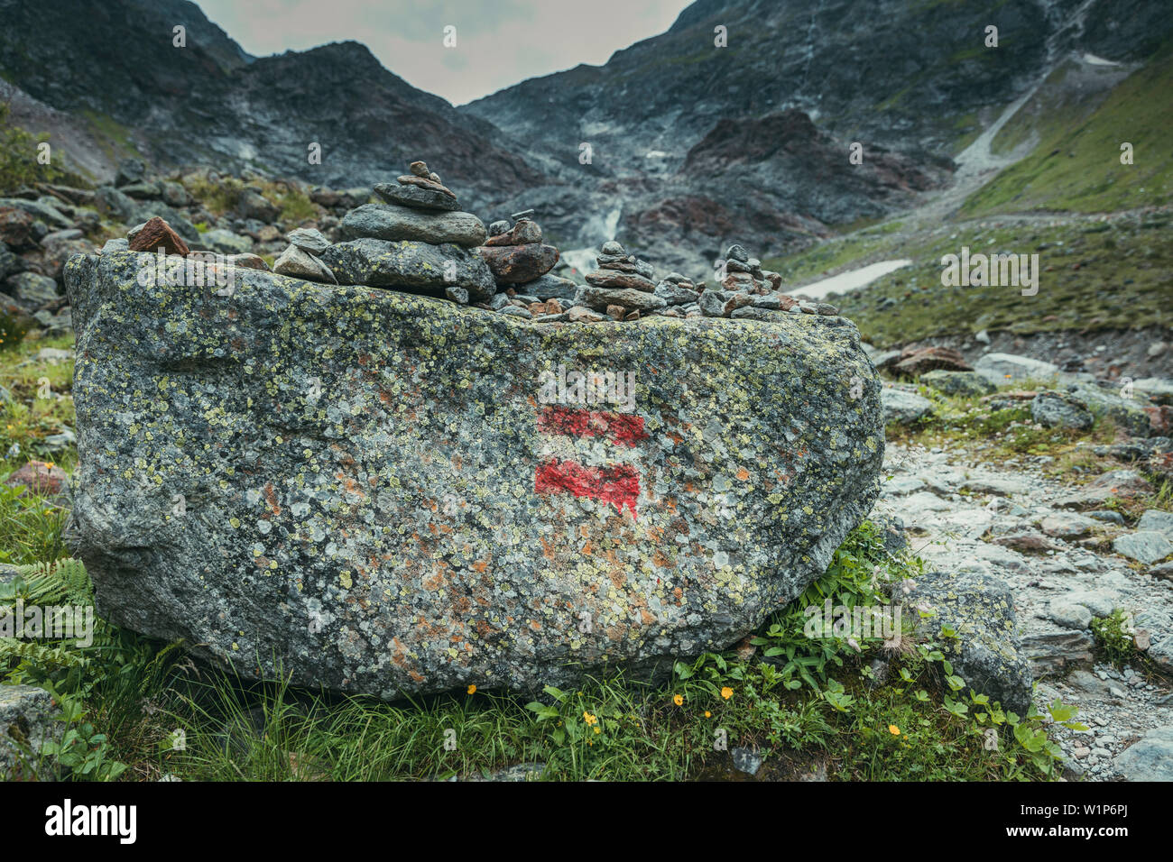 Rock on a mountain stream with signposting mark, E5, Alpenüberquerung, 4th stage, Skihütte Zams,Pitztal,Lacheralm, Wenns, Gletscherstube, Zams to Brau Stock Photo