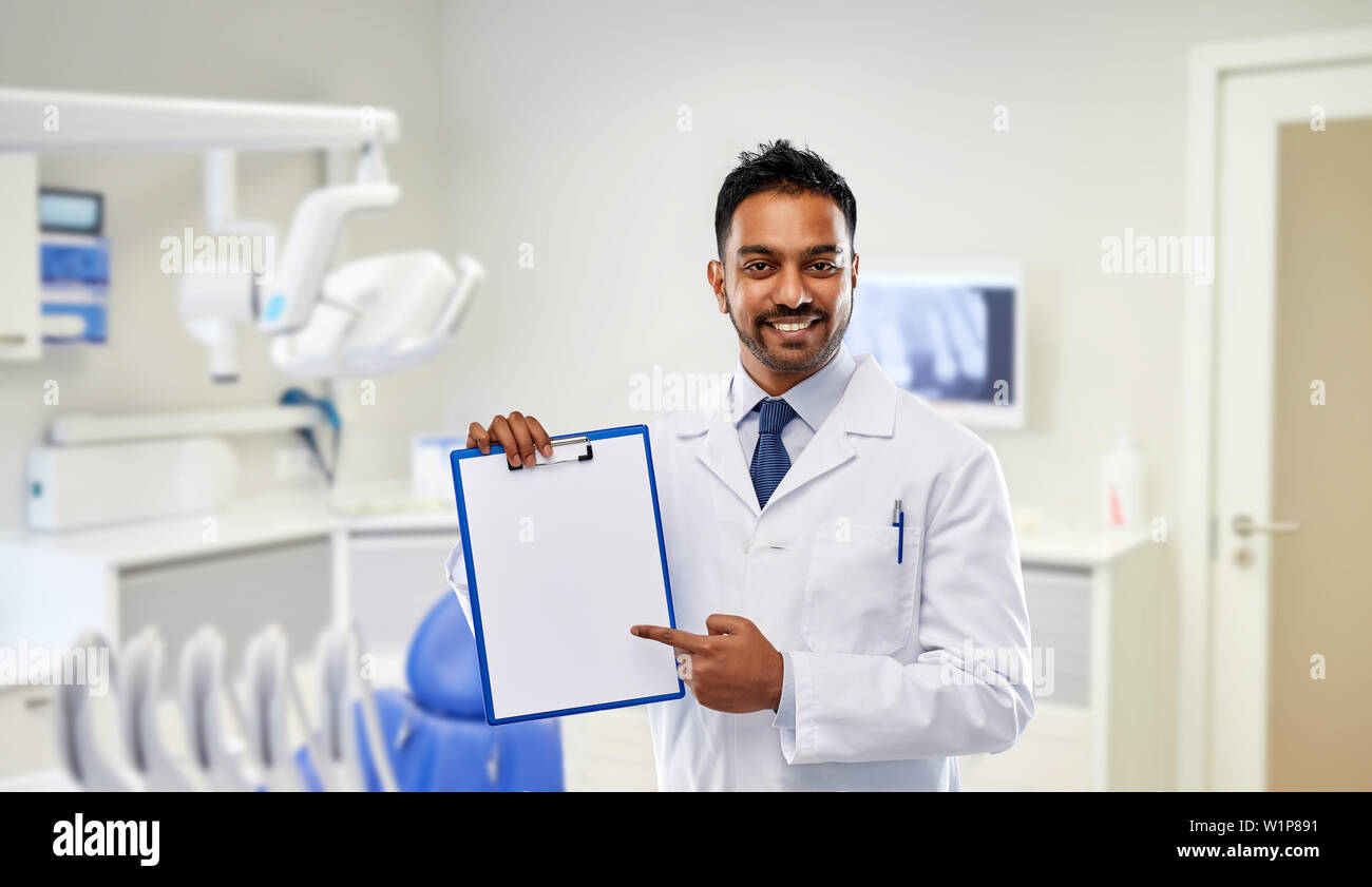 dentist with paper on clipboard at dental clinic Stock Photo Alamy