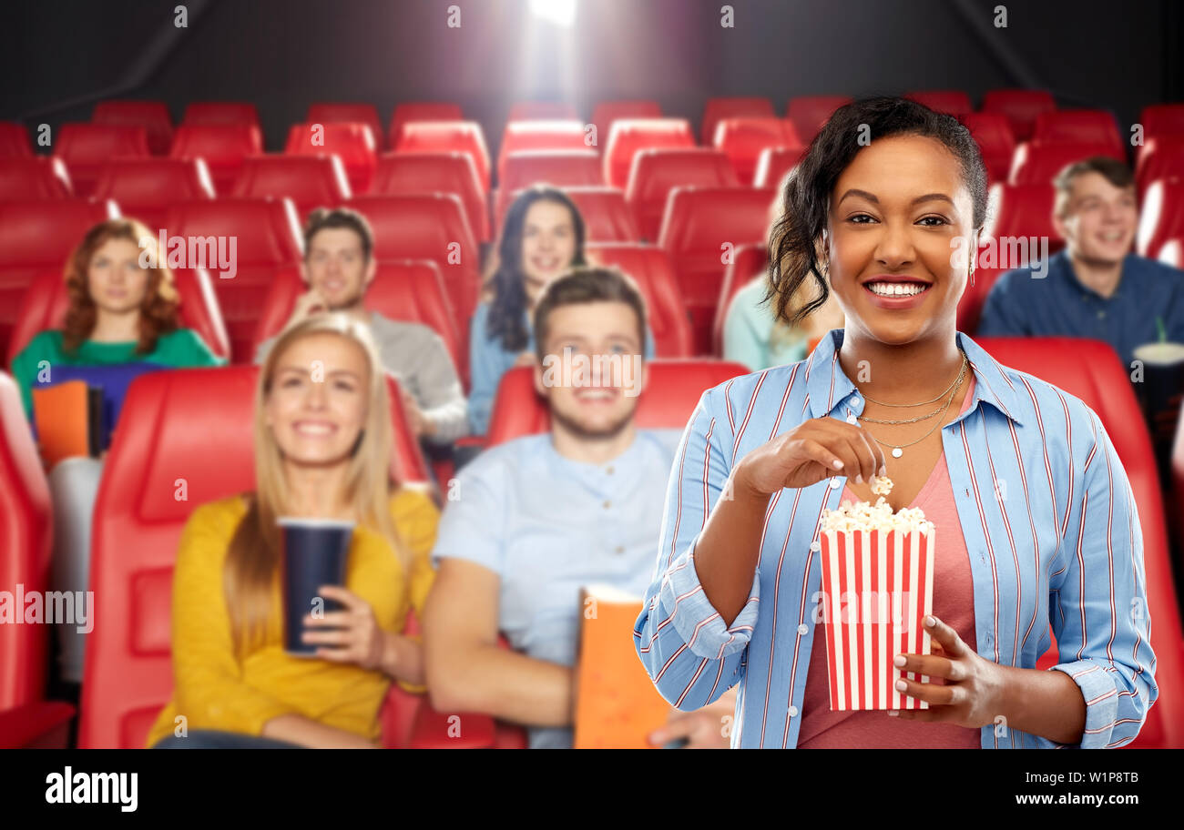 african woman eating popcorn at movie theater Stock Photo Alamy