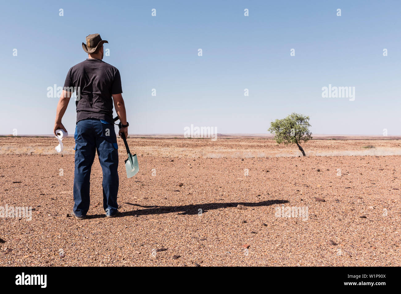 A man reflecting upon his toilet options. What's not buried carefully, will be dug out by wild animals, and due to the dry climate, things decompose e Stock Photo