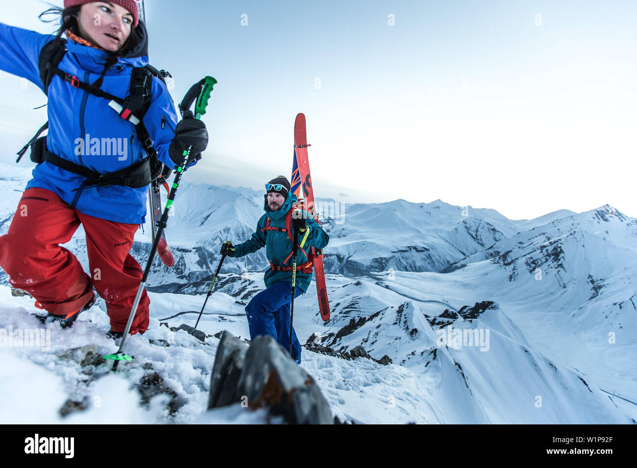 Two young skiers hikiing up through the deep powder snow to a mountain peak, Gudauri, Mtskheta-Mtianeti, Georgia Stock Photo