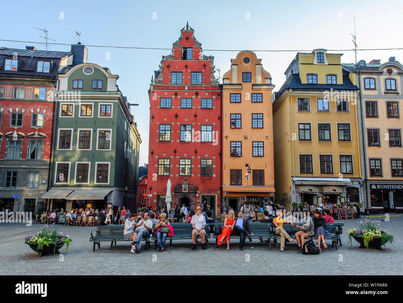 People sit on park benches in the main square Stortorget in the old town Gamla Stan, Stockholm, Sweden Stock Photo