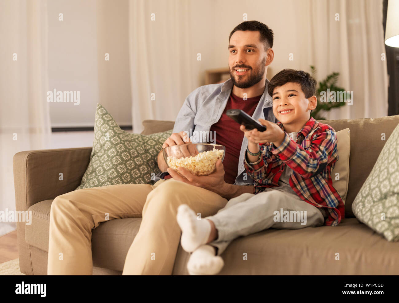 father-and-son-with-popcorn-watching-tv-at-home-stock-photo-alamy