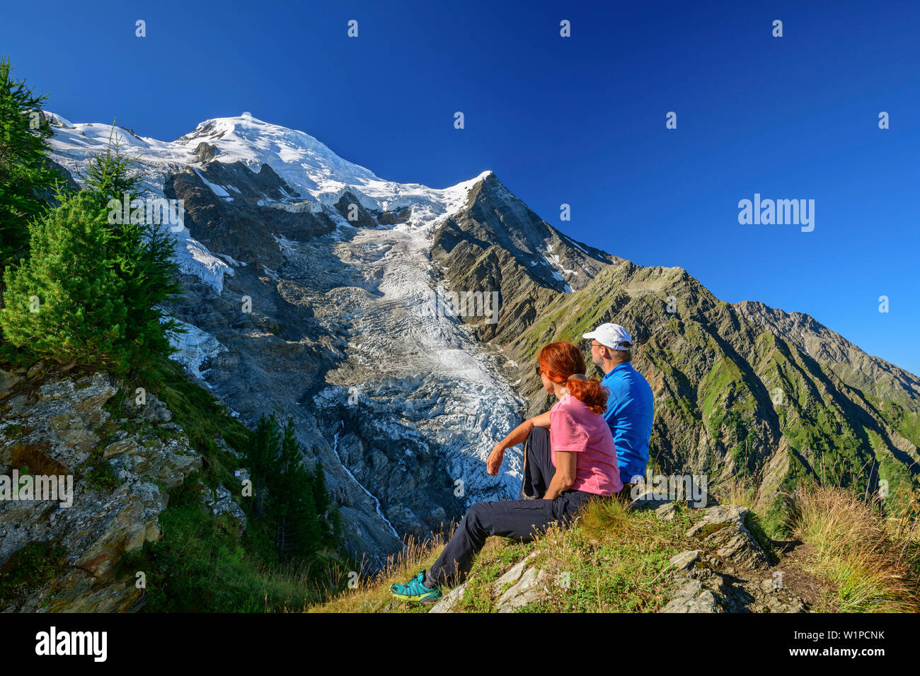 A man and a woman sitting on pointed back and views of Mont Blanc, pyramid, Mont Blanc, Grajische Alps, the Savoy Alps, Savoie, France Stock Photo