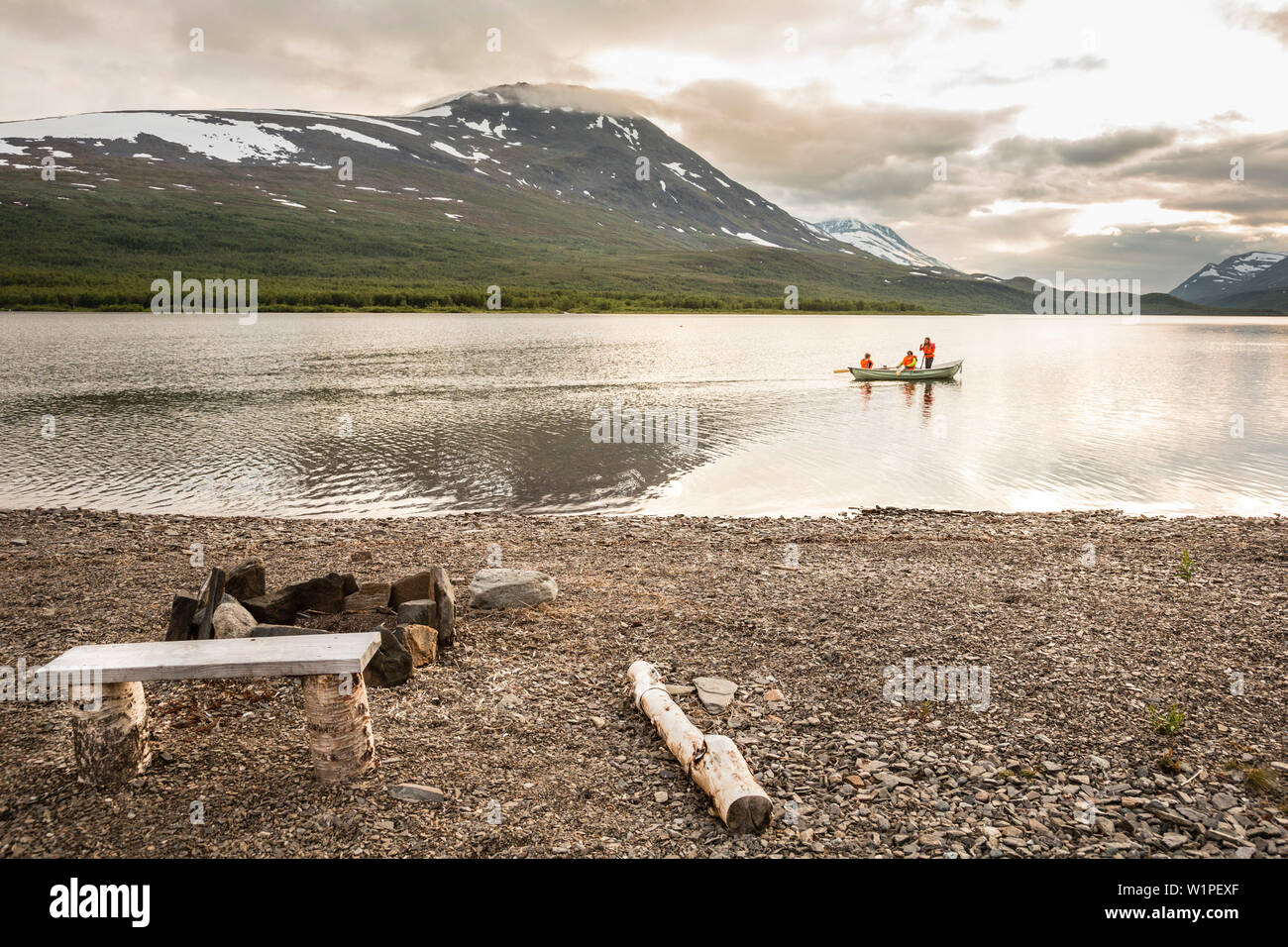 Two girls and a woman rowing a boat on Teusajaure. Kungsleden trekking. Laponia, Lapland, Sweden. Stock Photo