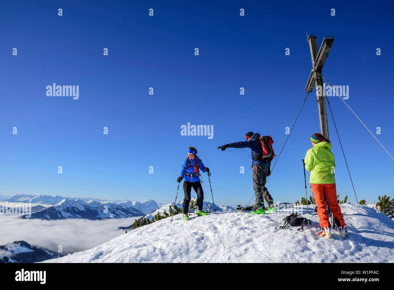 Three persons backcountry skiing standing at the summit of Trainsjoch, Trainsjoch, Bavarian Alps, Upper Bavaria, Bavaria, Germany Stock Photo