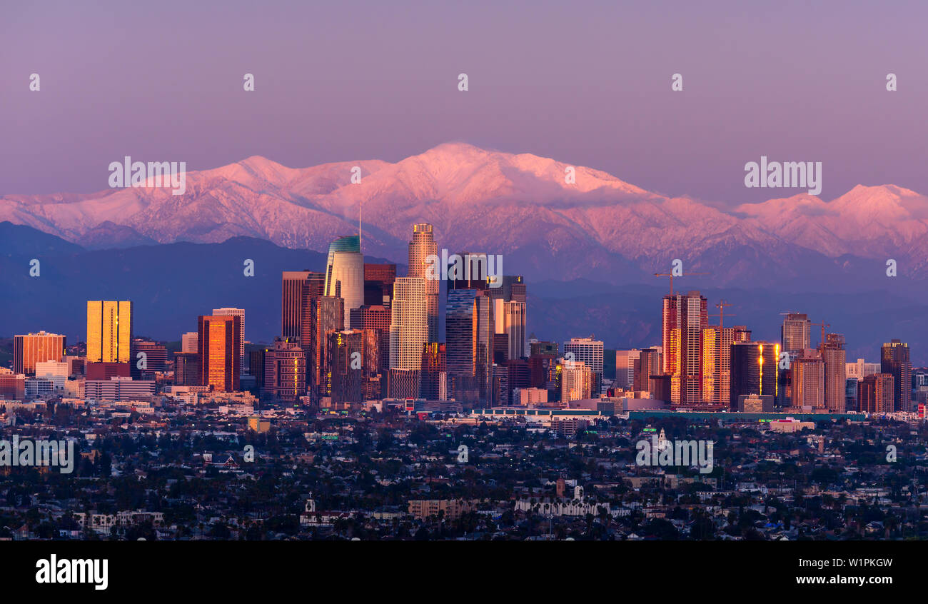 Downtown Los Angeles skyline with snow capped mountains behind at twilight Stock Photo