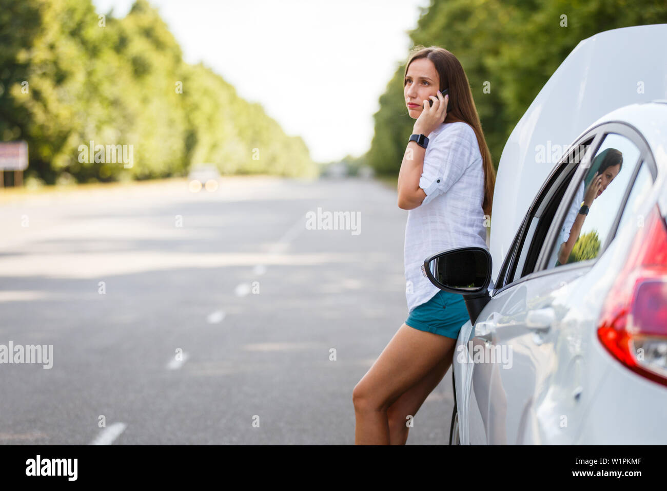 Young woman in trouble calling for help at the broken car Stock Photo