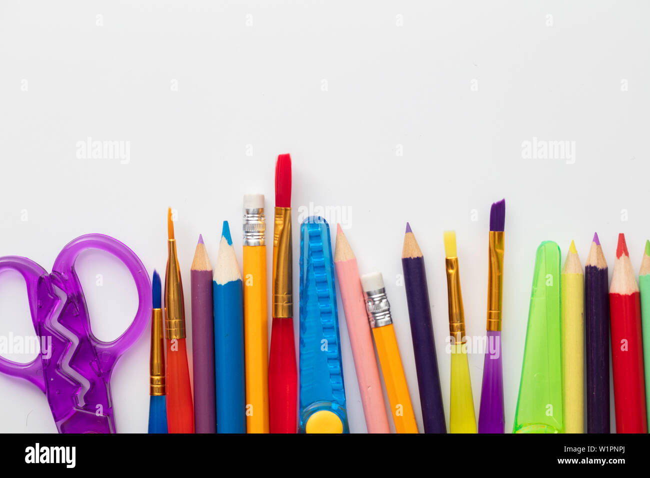 Row of school art and craft supplies on a white background Stock Photo -  Alamy