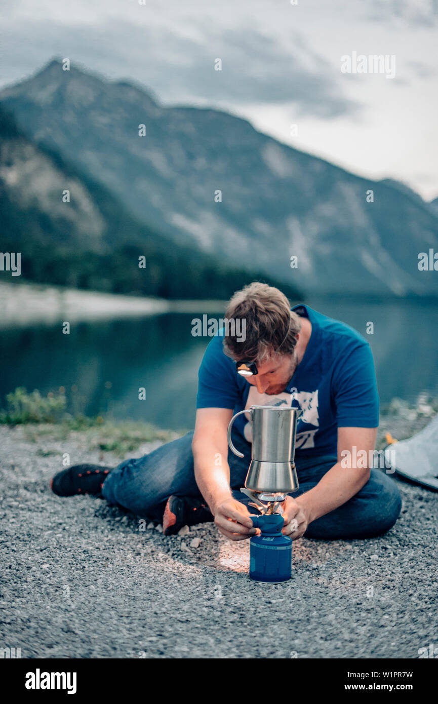 Man cooking coffee at Plansee, Plansee, Reutte, Tirol, austria, europe. Stock Photo