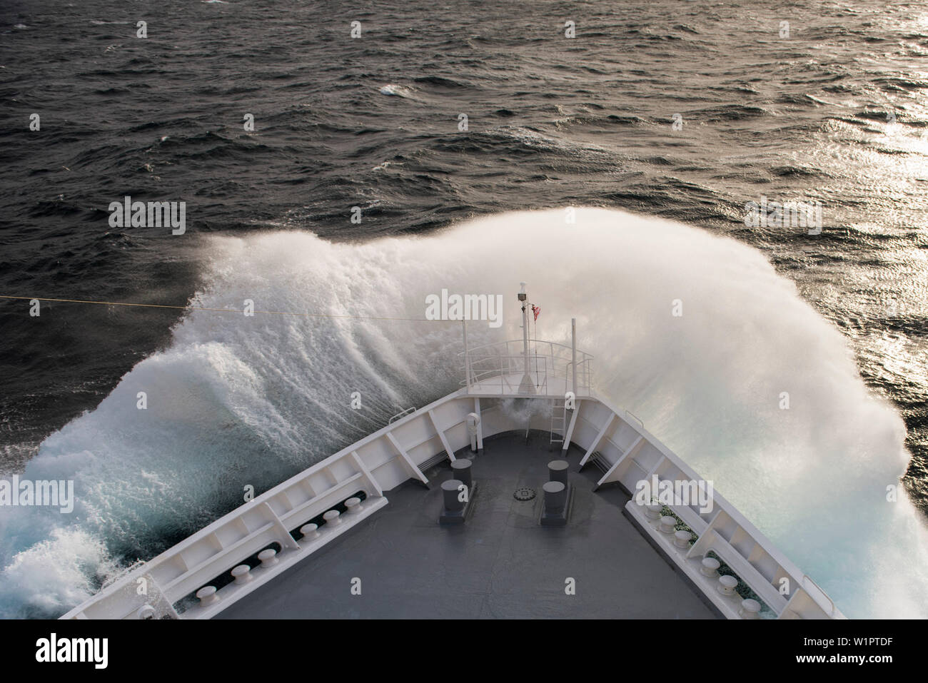 The bow of expedition cruise ship MS Bremen (Hapag-Lloyd Cruises) delves  into a large swell, sending a v-shaped cloud of spray from the ship, At Sea  Stock Photo - Alamy