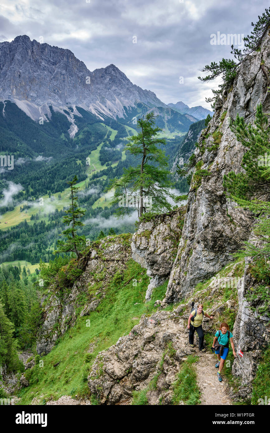 Two women hiking ascending towards hut Coburger Huette, Hoher Gang, Mieming Mountains, Tyrol, Austria Stock Photo