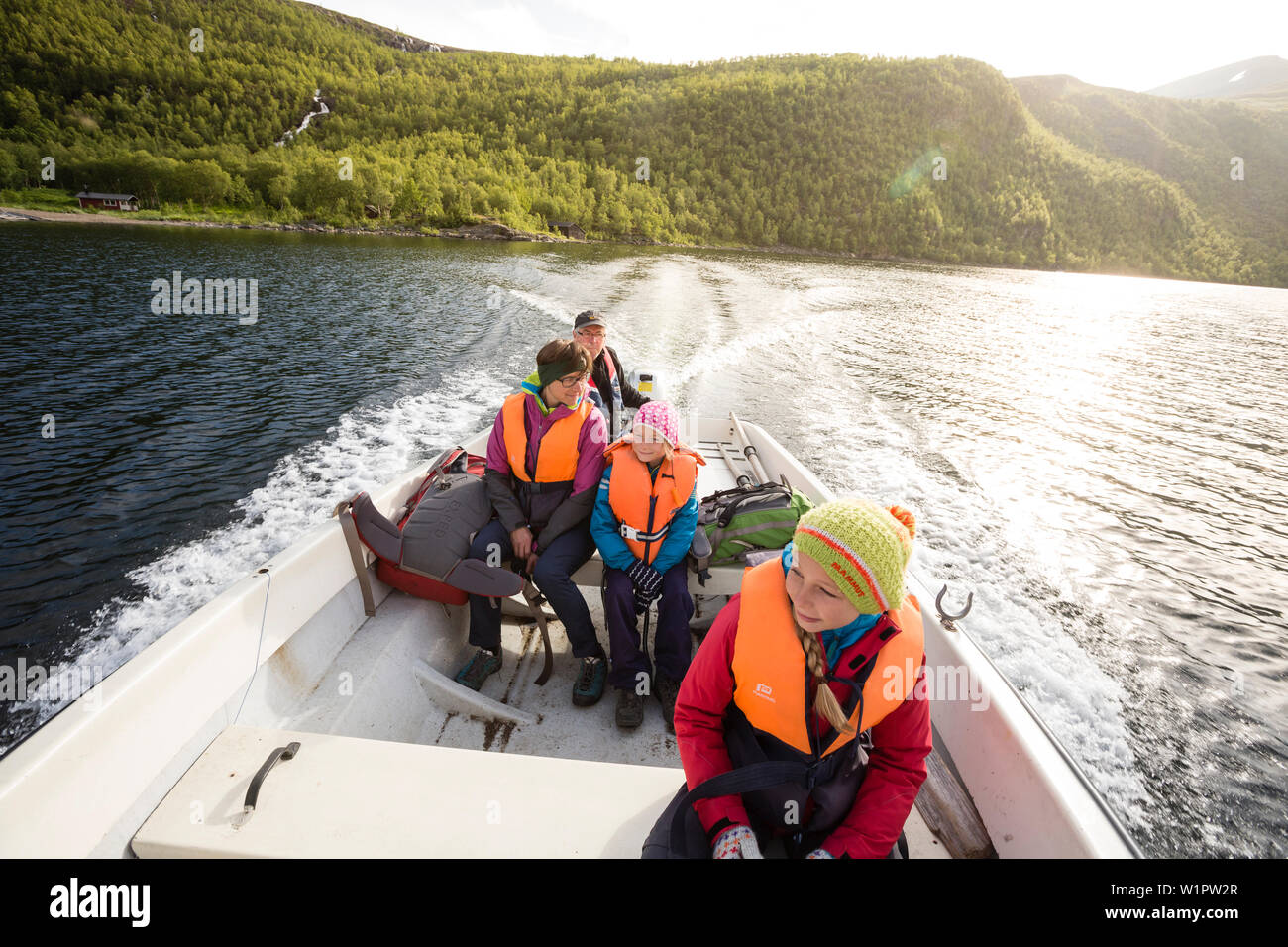 Two girls, a woman and a man in a boat. Boat taxi on lake Teusajaure provided by hut ward Loland Lindholm. Trekking on Kungsleden, Laponia, Lappland, Stock Photo