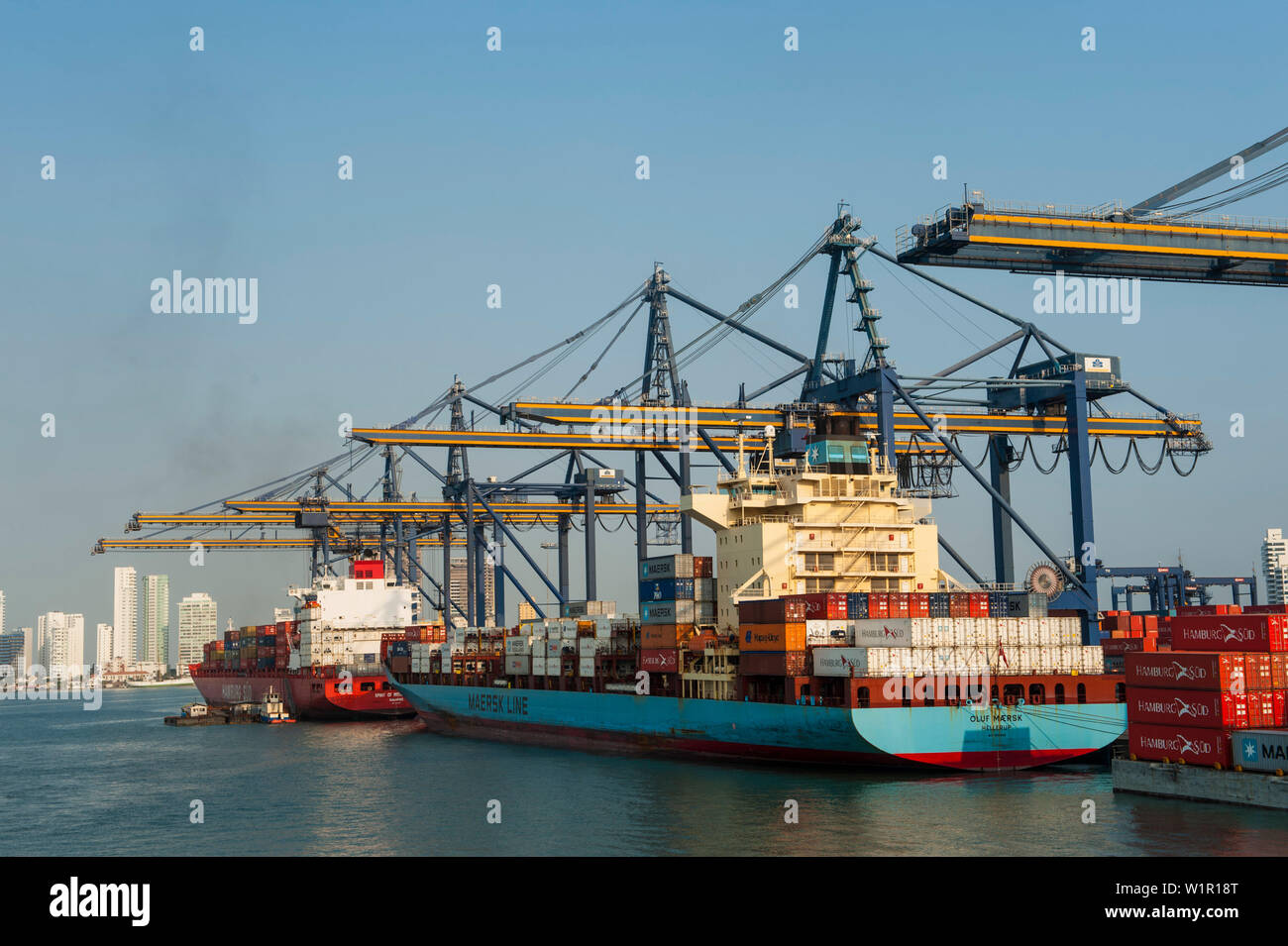 Two container ships are loaded and unloaded by a row of cranes in the port, Cartagena, Bolivar, Colombia, South America Stock Photo