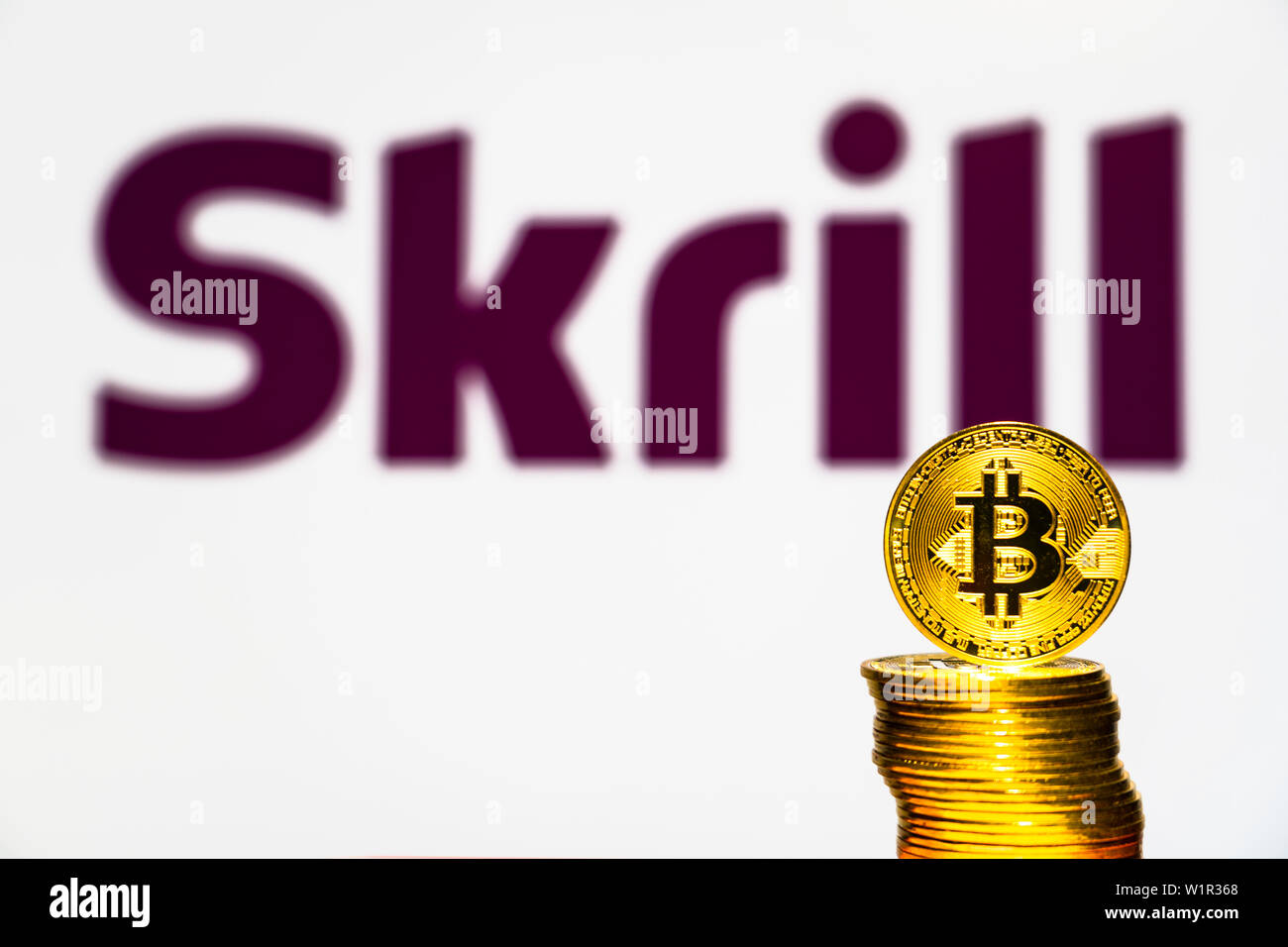 Gold Bitcoin coins with the Skrill logo on background screen. A new type of  business finance concept Stock Photo - Alamy