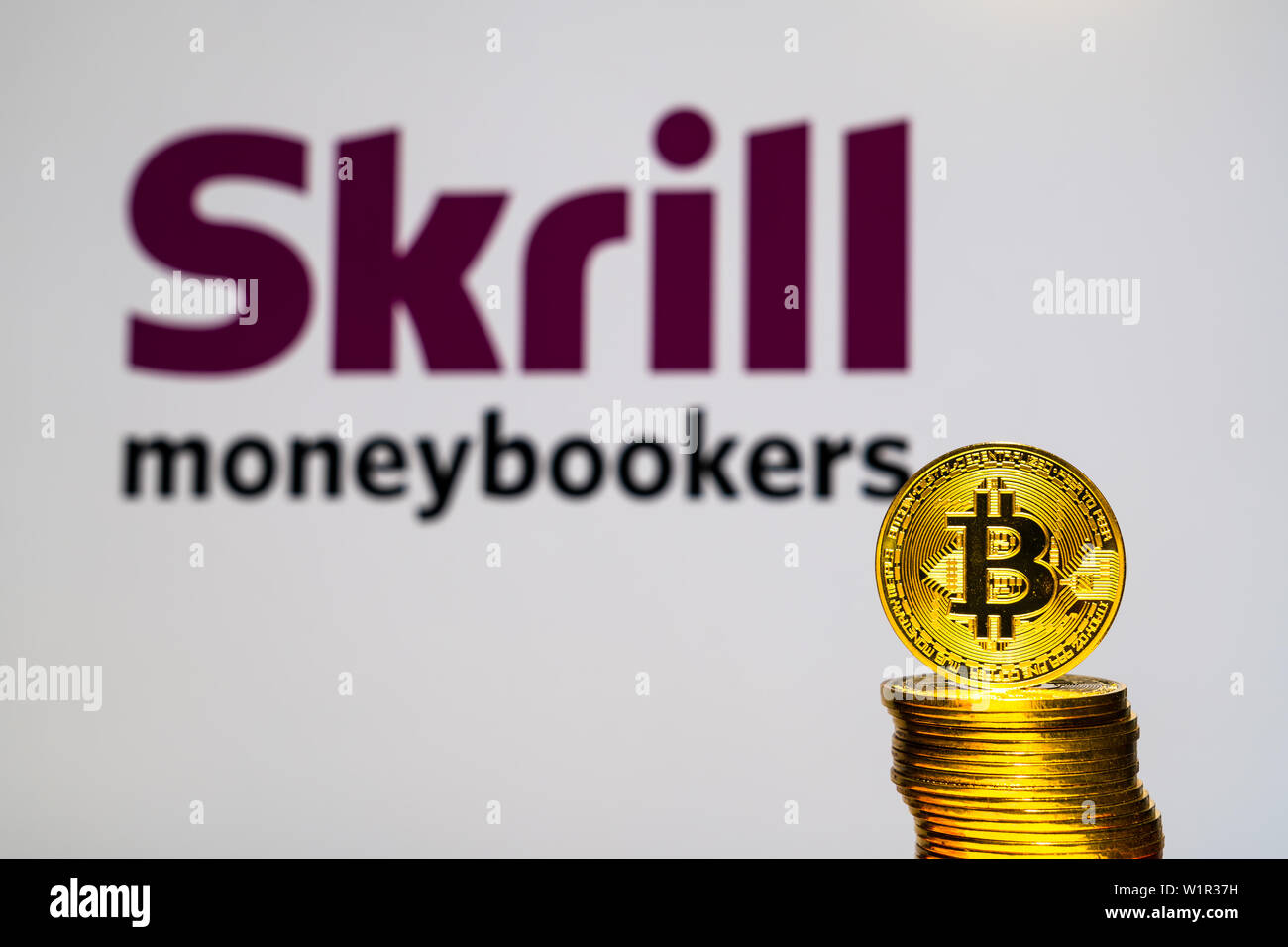 Gold Bitcoin coins with the Skrill logo on background screen. A new type of  business finance concept Stock Photo - Alamy