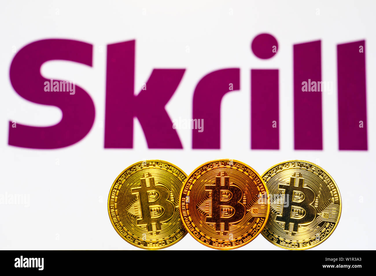 Gold Bitcoin coins with the Skrill logo on background screen. A new type of  business finance concept Stock Photo - Alamy