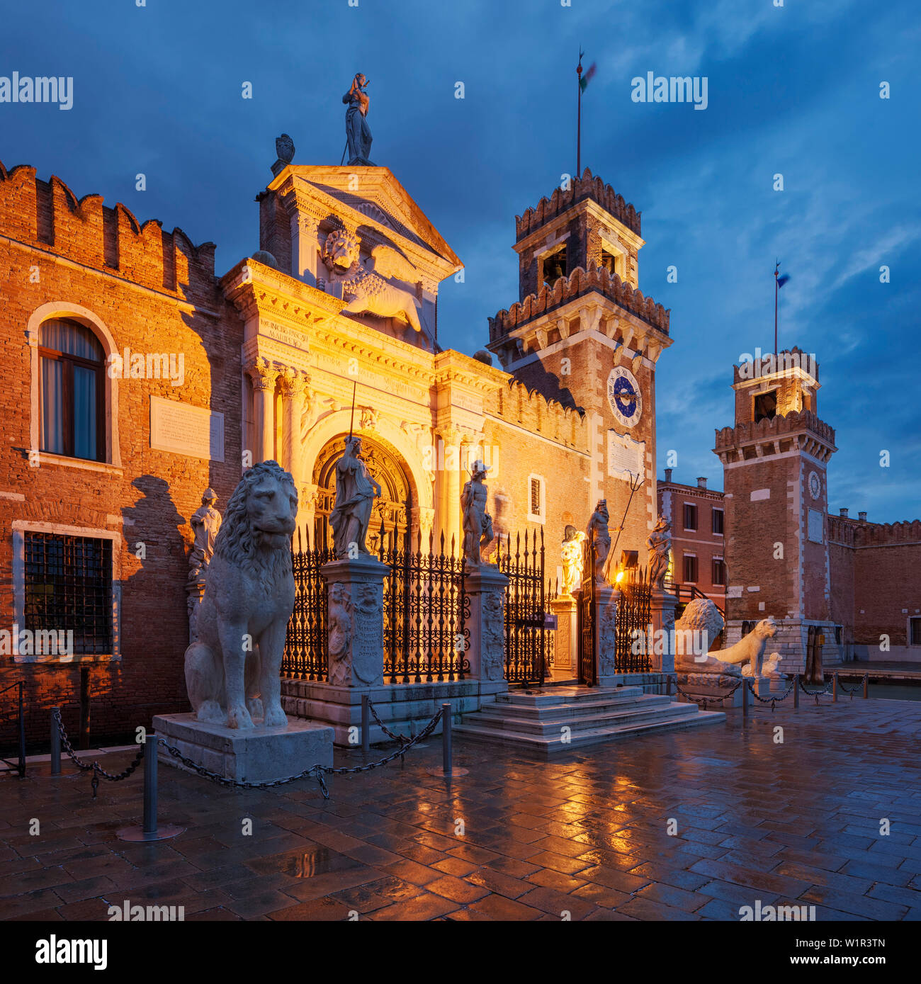 Arsenale di Venezia, the former shipyard and naval base in the blue of the night, with an illuminated wall and portal Ingresso di Terra left and Ingre Stock Photo