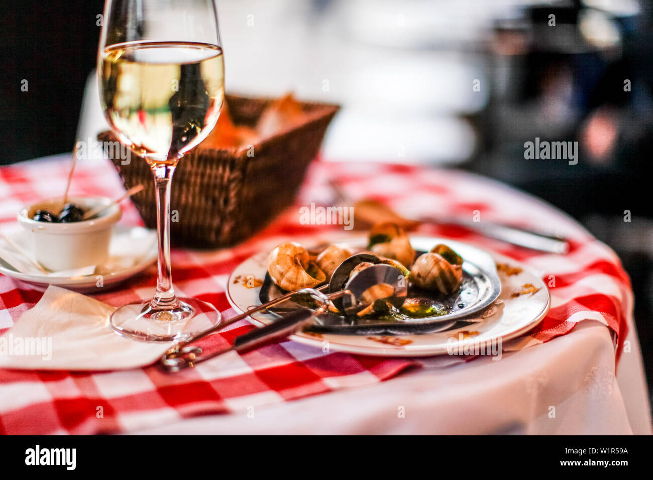 Escargots (snails) and a glass of white wine on the table in La Mère
