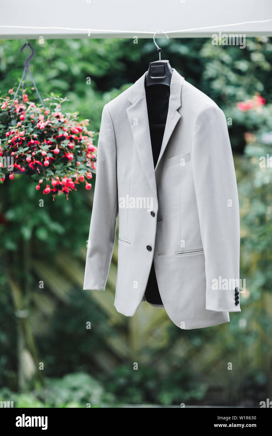 wedding groom gray suit hanging on a hanger by the tree. Preparations on the wedding morning Stock Photo