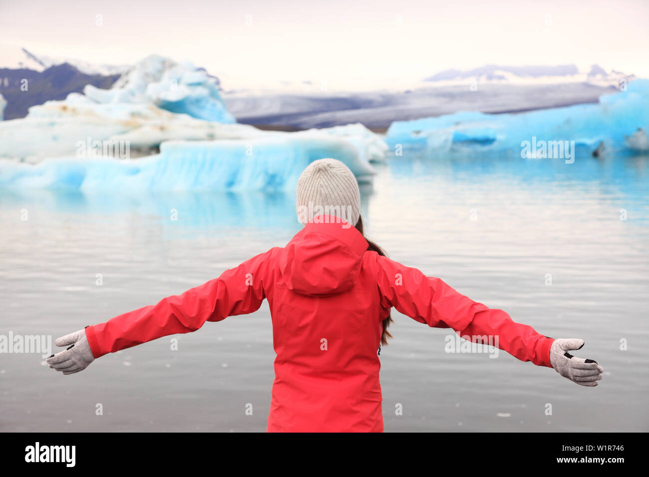 Freedom happy woman at glacier lagoon on Iceland serene and blissful. Tourist girl serene enjoying view of Jokulsarlon glacial lake. Woman in beautiful Icelandic nature landscape looking at iceberg. Stock Photo
