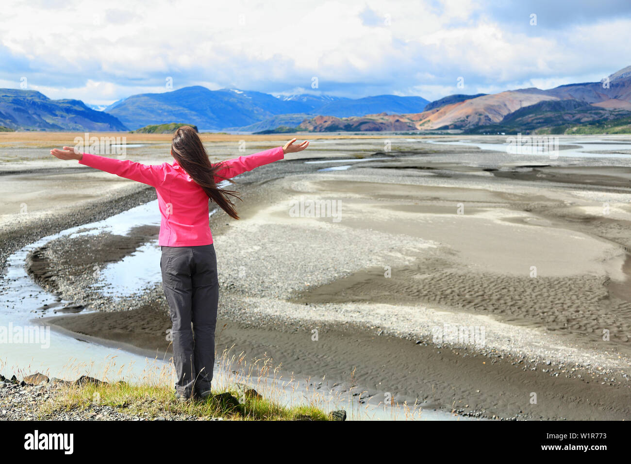 Woman enjoying view of Iceland black sand dunes in south Icelandic nature landscape. Serene person relaxing soaking in the natural beauty. Tourist visiting landmarks tourists attractions. Stock Photo