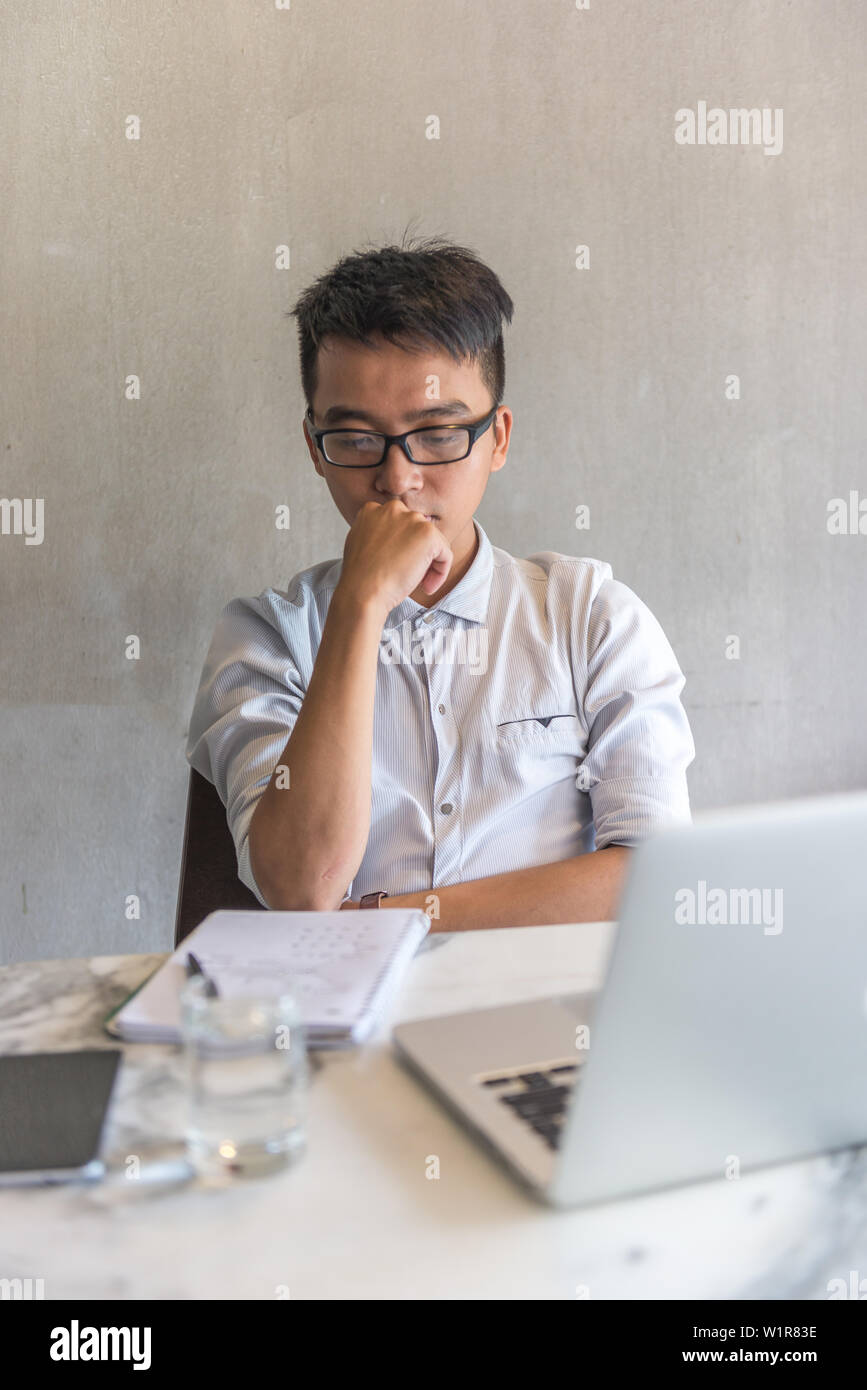 Office man looking at his notebook and thinking while working Stock ...