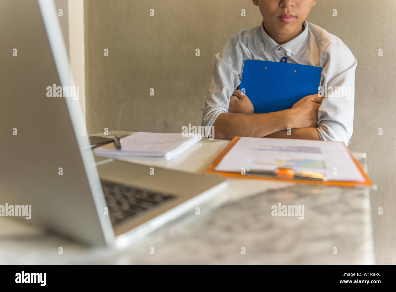 Young office staff holding folder in hands while working Stock Photo