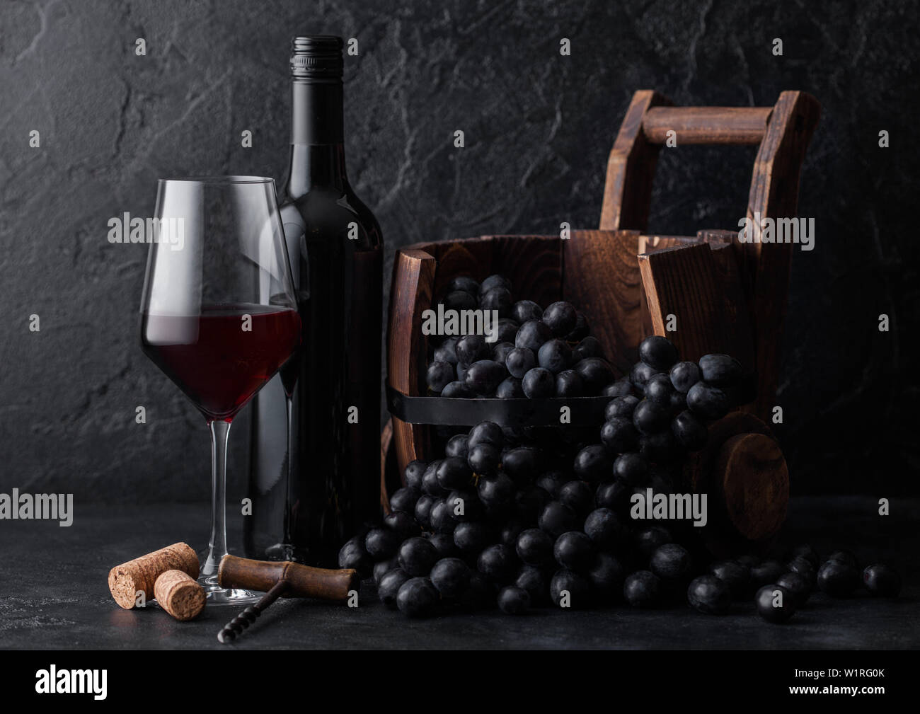 Elegant glass and bottle of red wine with dark grapes inside vintage ...